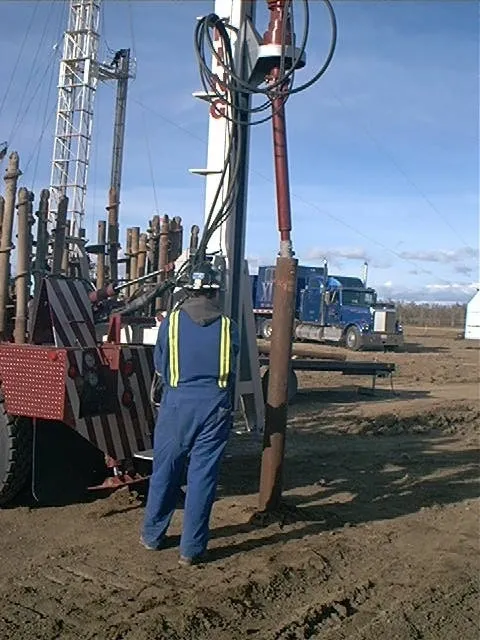 Anchor King operator installing a screw anchor beside the anchor truck