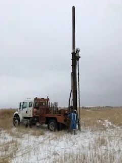 Anchor truck with mast raised in a snow-covered field